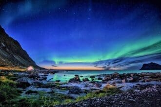 Stunning Aurora Borealis over Coastal Landscape at Night