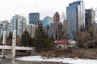 Winter view of Calgary skyline from riverfront park.