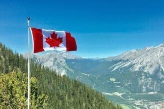 Canadian flag waving with mountainous backdrop