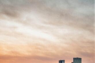 Calgary skyline at sunset with river in foreground.