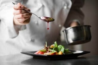 Chef finishing a gourmet dish in Yaletown restaurant.