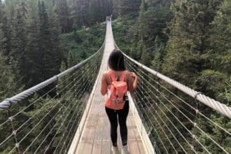 Person walking on Blackshale Suspension Bridge in Kananaskis, Canada.