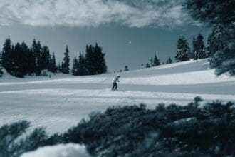 Skiing on snowy mountain slope with pine trees