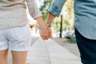 Couple holding hands on a romantic walk in Toronto.