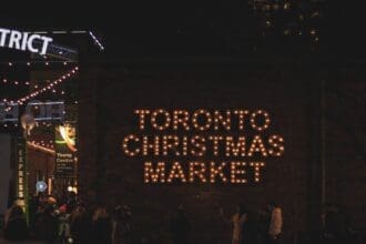 Illuminated Toronto Christmas Market sign at night.