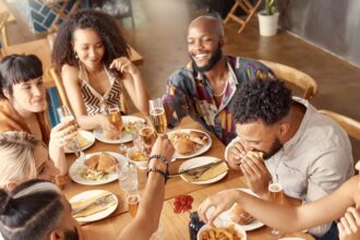a group of young friends enjoying a meal together at a restaurant