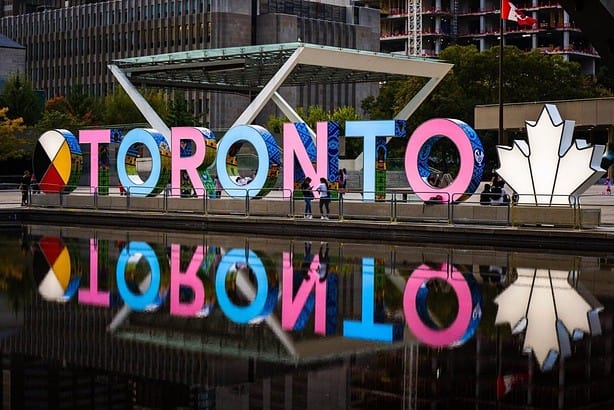 Colorful Toronto sign with reflection in water.