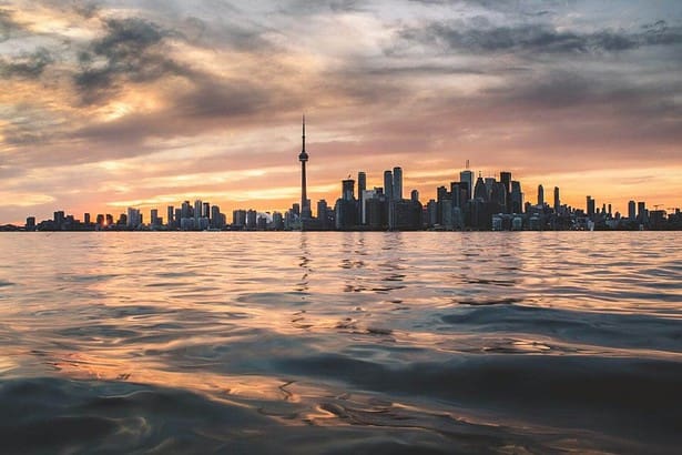 Sunset silhouette of Toronto skyline from the water.