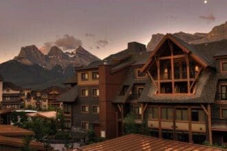 Luxury Canmore hotel at dusk with mountain backdrop