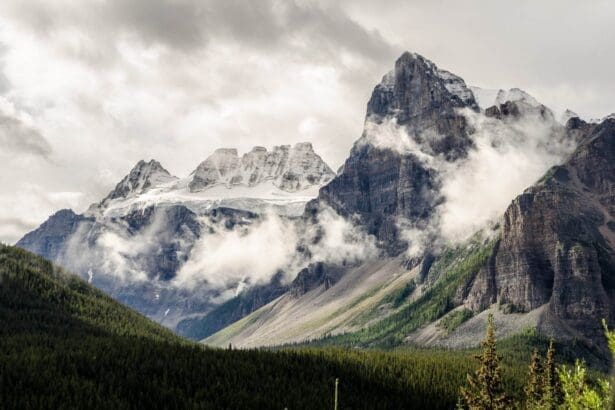 Majestic Alberta mountains with clouds and forest.