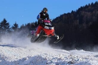 Snowmobile jumping on Ontario winter trail.