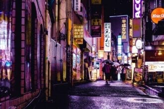 Bustling night market street with vibrant lights and shoppers.