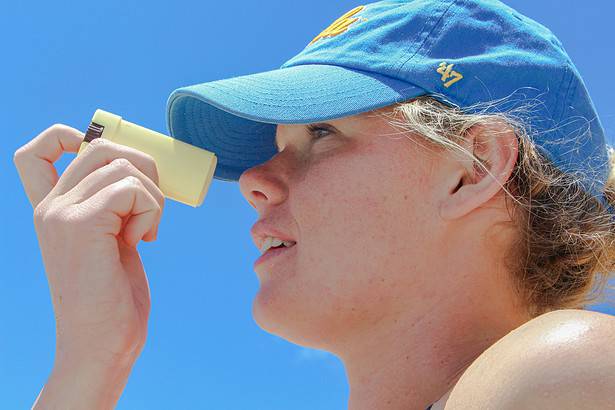 Woman applying sunscreen stick outdoors